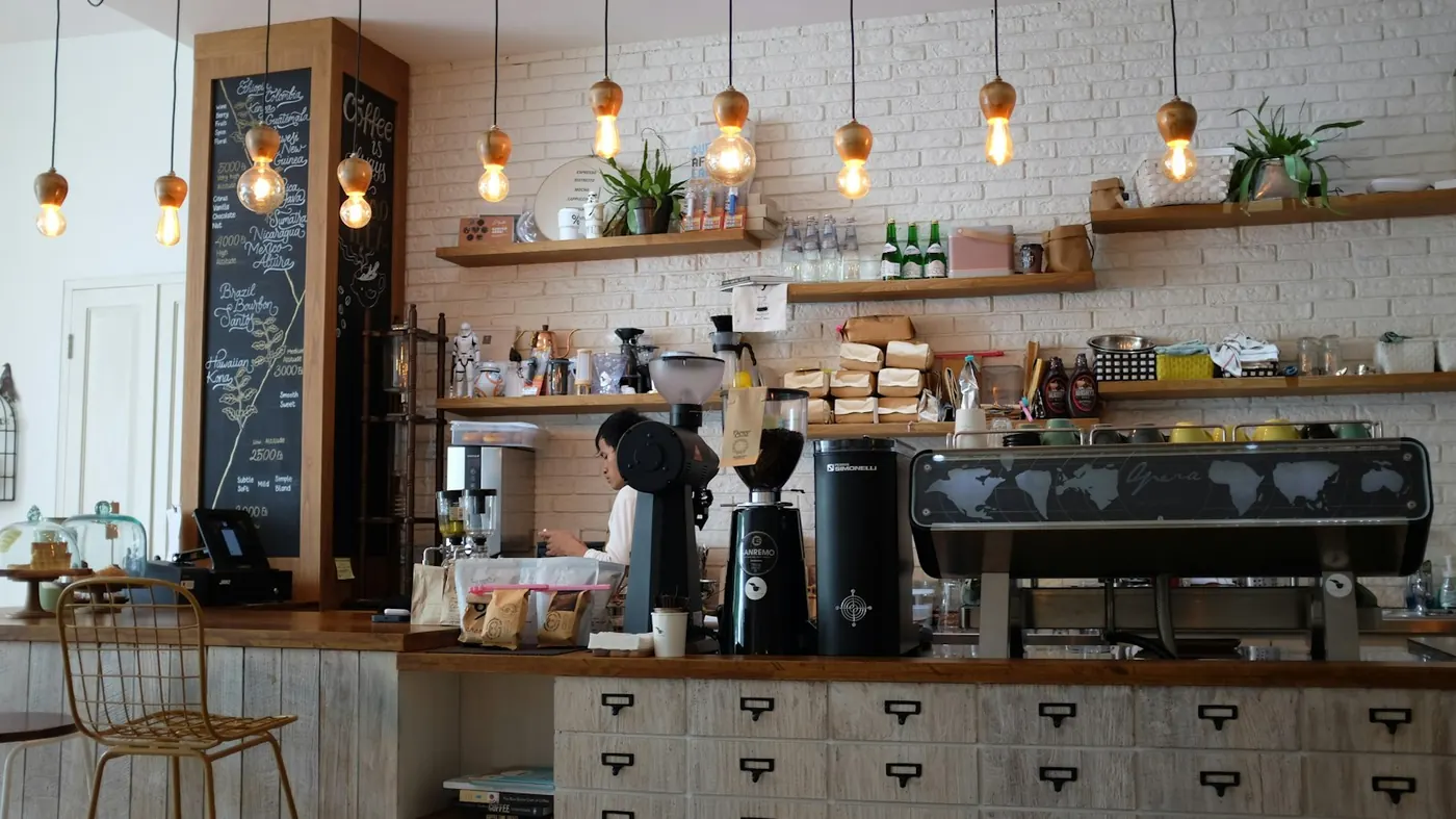 Barra de cafetería con cafetera y vitrina